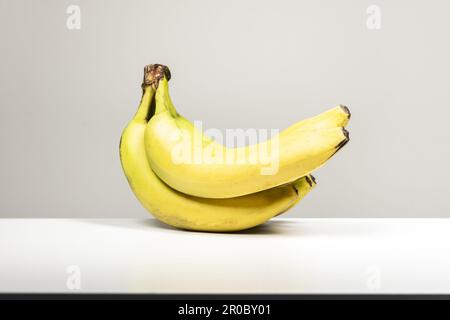 Ein Haufen reifer Bananen auf einer weißen Oberfläche Stockfoto