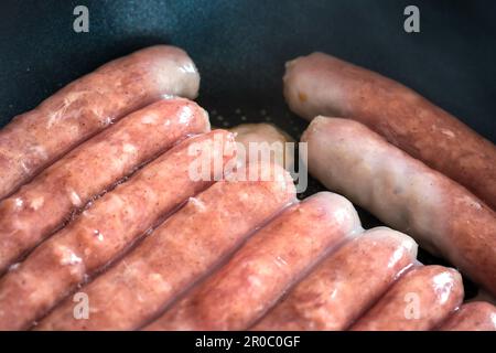 Schweinewürste Chipolatas Pfannenbraten. Stockfoto