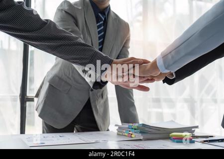 Business-Team für Analysten, das nach erfolgreicher Analyse von Dashboard-Papieren für Geschäftsstrategie und Marketing Hand in Hand ging. Teamarbeit und Stockfoto