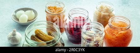 Panorama fermentierter Lebensmittel. Hausgemachte Gemüsekonserven. Sauerkraut, Gurken, Kimchi usw. in Glasgefäßen. Gesunde probiotische Diät Panorama-Banner Stockfoto