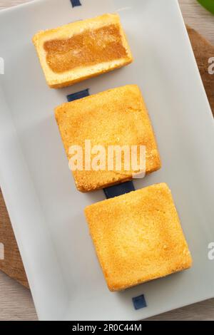 Köstliches taiwanesisches berühmtes Ananaskuchen Gebäck als Dessert auf einem Teller auf einem Holztisch mit heißem Tee. Stockfoto