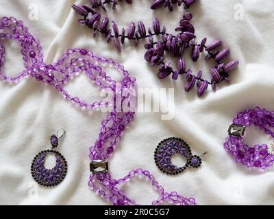 Amethyst-Halskette und Ohrringe auf weißem Hintergrund. Stockfoto