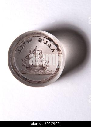 Siegelmatrix. Signet Matrix – Seal Matrix, 1750-1850. Möglicherweise in Birmingham hergestellt. Präsentiert von Francis Buckley, 1934. Eine „SIGnet“- oder „SEAL Matrix“ ist ein kleiner Stempel, der verwendet wird, um das Zeichen seines Besitzers in Wachs auf Dokumente zu drücken. Dies ist eine von 27 Sammlungen, die das Museum 1934 erworben hat. Die meisten Beispiele bestehen fein aus geformtem, durchsichtigem Glas, in diesem Fall klar. Dieses Beispiel trägt das Design eines Segelschiffs und lautet „alles in Ordnung“. Stockfoto