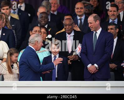 König Karl III. Begrüßt den Prinzen von Wales (rechts), Prinz George (Mitte) und Prinzessin Charlotte bei der Ankunft in der Royal Box vor dem Krönungskonzert, das auf dem Gelände von Windsor Castle, Berkshire, stattfindet, um die Krönung von König Karl III. Und Königin Camilla zu feiern. Foto: Sonntag, 7. Mai 2023. Stockfoto