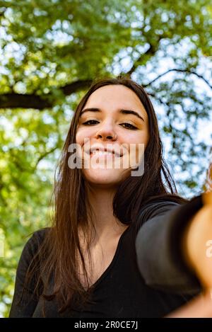 Ein schönes Mädchen macht ein Selfie lächelnd in der Kamera Stockfoto