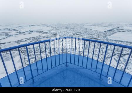 Schiffsbogen eines kleinen Schiffes, das durch das arktische Meer mit Eisbergen vor dem Boot segelt. Svalbard, Spitsbergen, Norwegen, Nordsee Stockfoto