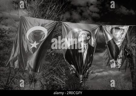 Die Ausstellung von Bannern und Flaggen, die hoch oben an einem Seil gegen den blauen Himmel in Antalya, der Türkei, fliegen, zeigt die politische und nationale Identität des Landes. Stockfoto