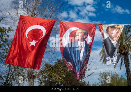 Die Ausstellung von Bannern und Flaggen, die hoch oben an einem Seil gegen den blauen Himmel in Antalya, der Türkei, fliegen, zeigt die politische und nationale Identität des Landes. Stockfoto