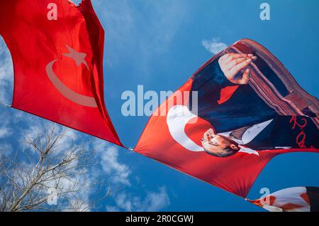 Die Ausstellung von Bannern und Flaggen, die hoch im Wind an einem Seil vor einem blauen Himmel in Antalya, Türkei, fliegen, zeigt die Politik und nationa des Landes Stockfoto