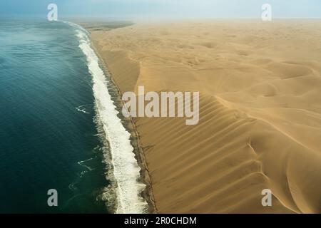 Luftaufnahmen an der namibischen Küste, wo die Sanddünen auf den Atlantischen Ozean treffen, Namibia Stockfoto