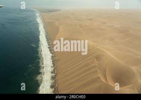 Luftaufnahmen an der namibischen Küste, wo die Sanddünen auf den Atlantischen Ozean treffen, Namibia Stockfoto