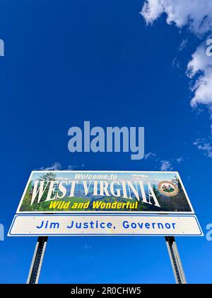 Ein „Welcome to West Virginia Wild and Wonderful“-Metallschild an einer Raststätte auf der Interstate vor blauem Himmel. Stockfoto