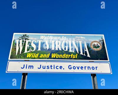 Ein „Welcome to West Virginia Wild and Wonderful“-Metallschild an einer Raststätte auf der Interstate vor blauem Himmel. Stockfoto