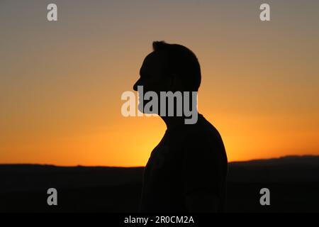 Silhouette eines Mannes bei Sonnenuntergang Stockfoto