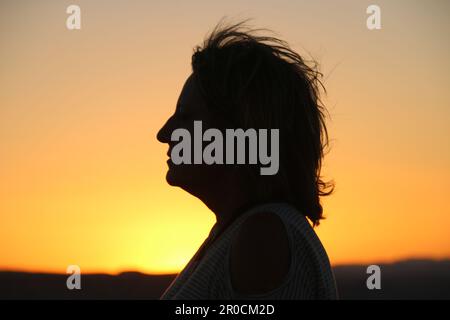 Silhouette eines Frauenprofils bei Sonnenuntergang Stockfoto