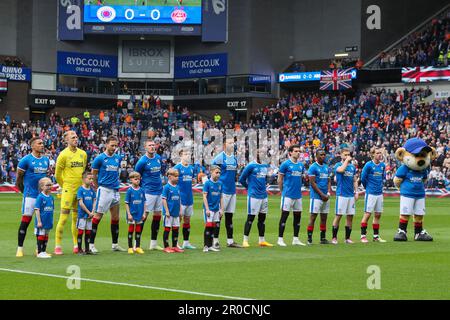 Glasgow, Großbritannien. 07. Mai 2023. Vor dem Beginn des schottischen Premiership-Spiels zwischen Rangers und Aberdeen schlossen sich in Ibrox, der Heimat der Rangers, der Rangers und Aberdeen Teams zusammen mit Fans zusammen, um die Nationalhymne zu Ehren der Krönung von König Charles am 6. Mai 2023 zu singen Credit: Findlay/Alamy Live News Stockfoto