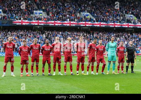 Glasgow, Großbritannien. 07. Mai 2023. Vor dem Beginn des schottischen Premiership-Spiels zwischen Rangers und Aberdeen schlossen sich in Ibrox, der Heimat der Rangers, der Rangers und Aberdeen Teams zusammen mit Fans zusammen, um die Nationalhymne zu Ehren der Krönung von König Charles am 6. Mai 2023 zu singen Credit: Findlay/Alamy Live News Stockfoto