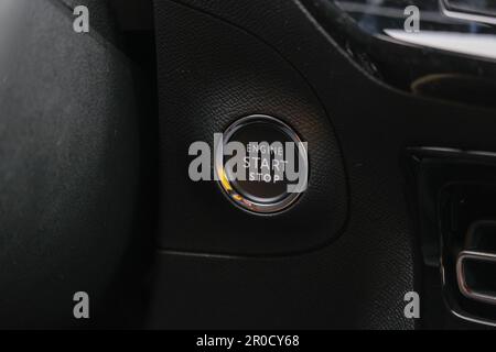 Schließen Sie die schlüssellose Motorstarttaste STOP (Stopp), die Zündtaste Car. Selektiver Fokus. Stockfoto