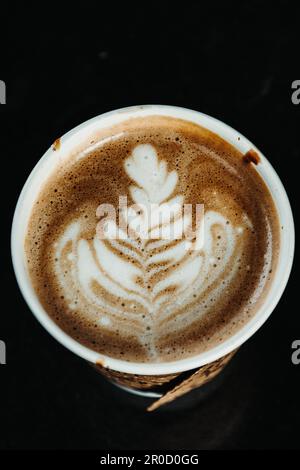 Ein Standbild einer Kaffeetasse aus weißer Keramik auf einer strukturierten dunklen Oberfläche, aufgenommen in San Francisco Stockfoto