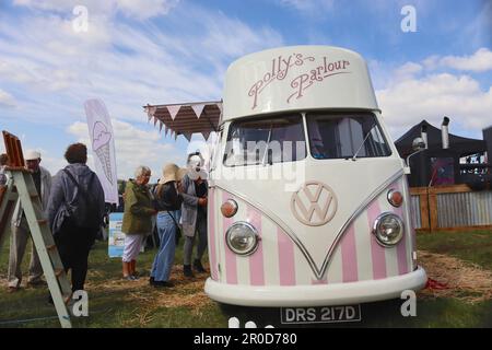 Eine Schlange von Kunden, die im „Matilda“, einem restaurierten 1966 VW großen Spit-Lieferwagen, der in eine mobile Eisdiele verdeckt ist, auf den Service warten, im Mai 2023. Stockfoto