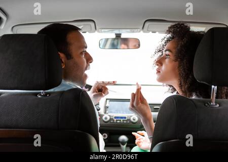 Wütendes Nahöstliches Paar, Das In Einem Konflikt Unstimmigkeiten In Automobile Zum Ausdruck Bringt Stockfoto