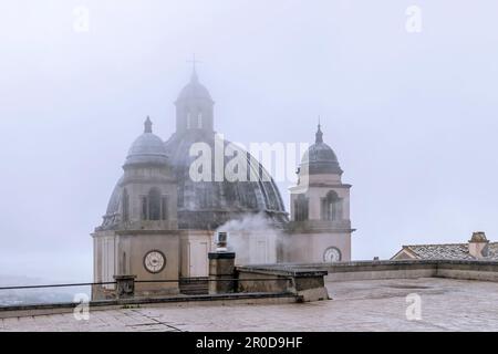 Der Gipfel der Kathedrale Santa Margherita, das historische Zentrum von Montefiascone, Italien, im Nebel eines regnerischen Tages Stockfoto