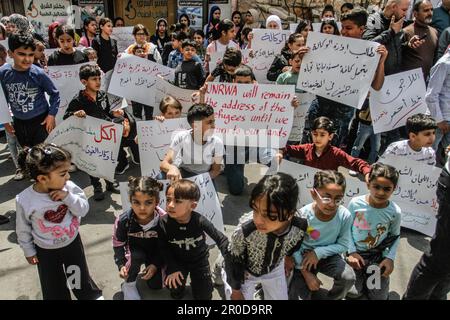 Nablus, Palästina. 08. Mai 2023. Palästinensische Kinder halten Schilder vor dem Hauptquartier des Hilfswerks der Vereinten Nationen (UNRWA) im Flüchtlingslager Askar, die die Bereitstellung von Dienstleistungen, die Eröffnung von Gesundheitszentren und Schulen fordern. Kredit: SOPA Images Limited/Alamy Live News Stockfoto