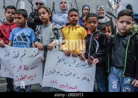 Nablus, Palästina. 08. Mai 2023. Palästinensische Kinder halten Schilder vor dem Hauptquartier des Hilfswerks der Vereinten Nationen (UNRWA) im Flüchtlingslager Askar, die die Bereitstellung von Dienstleistungen, die Eröffnung von Gesundheitszentren und Schulen fordern. Kredit: SOPA Images Limited/Alamy Live News Stockfoto