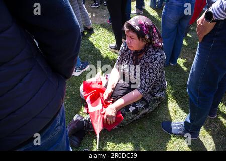 Izmir, Konak, Truthahn 04.30.2023 eine alte türkische Frau ist müde von den Feiern und sitzt mit ihrer türkischen Flagge auf dem Gras Stockfoto