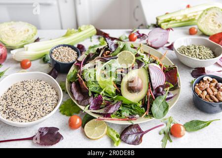 Salat mit Avocado und Gemüse gemischte grüne Salatblätter, fertig zum Essen. Stockfoto