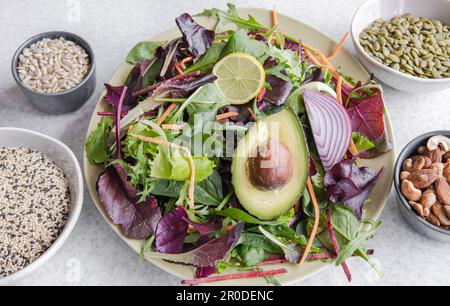 Salat mit Avocado und Gemüse gemischte grüne Salatblätter, fertig zum Essen. Stockfoto