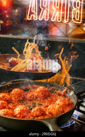 Küche in einer traditionellen italienischen Trattoria, die Spaghetti und Fleischbällchen kocht. Stockfoto