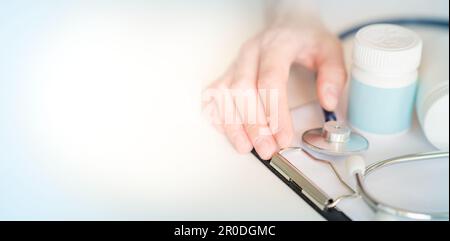 Medizinisches Konzept auf blauem Hintergrund. Stethoskop, Pillen, Notizblock, Blatt Papier, Stift. Platz für Text. Stockfoto