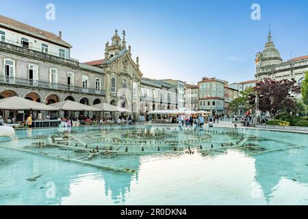 Braga, Portugal - 30. April 2023: Sonnenuntergang über Praca da Republica im historischen Zentrum von Braga, Portugal, mit Reflexion im Brunnen. Stockfoto