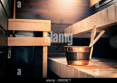 Sauna in Finnland. Whirlpool in Sommerkabine. Wellness-Dampfbad aus Holz. Traditioneller finnischer entspannender Lifestyle. Wassereimer und Kelle. Stockfoto