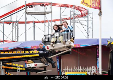 Zwei Mädchen im Teenageralter, die auf einem Rummelplatz in einem Vergnügungspark oder auf einer Kirmes fahren Stockfoto