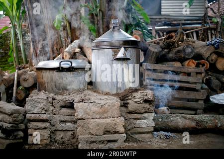 Ländliche Küche. Traditionelle Öfen, die von den Bewohnern im ländlichen Indonesien verwendet werden, aus Ton, mit Holz angetrieben, Kochen von Speisen auf Erdofen mit trockenen Blättern und Stockfoto