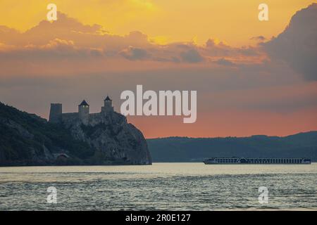 Die Festung Golubac Felsen während eines Sonnenuntergangs auf der Donau mit feurigem Himmel. Foto aufgenommen am 30. April 2023, im Dorf Coronini, Caras-Severin Stockfoto