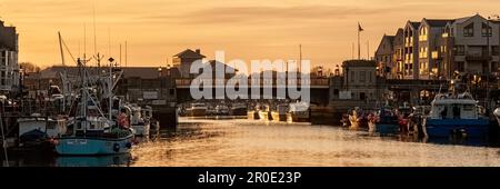 WEYMOUTH, DORSET, Großbritannien - 15. MÄRZ 2009: Panoramablick auf den alten Hafen bei Nacht mit Booten am Kai Stockfoto