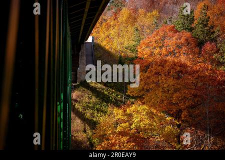 Die Cut River Bridge in Michigan, umgeben von leuchtenden Herbstfarben der Wälder Stockfoto