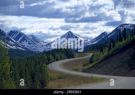 Alaska Highway vor schneebedeckten Bergen, Yukon Territory, Kanada, Amerika Stockfoto