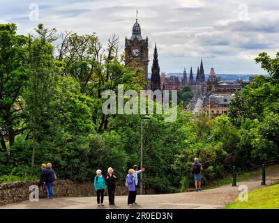 Walkers on Calton Hill, Blick auf den Uhrenturm des Balmoral Hotel und Princes Street, Stadtzentrum, Edinburgh, Schottland, Großbritannien Stockfoto