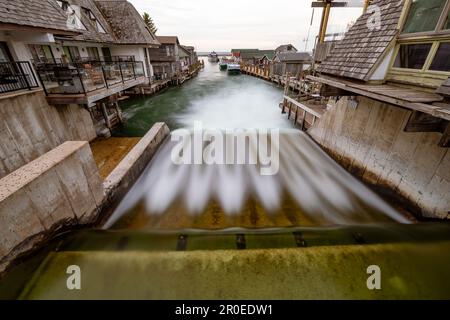 Lange Sicht auf einen ruhigen Fluss, der sich durch eine friedliche Wohngegend in Fishtown schlängelt Stockfoto