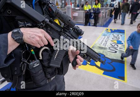 Manchester, Großbritannien. 08. Mai 2023. Ein Polizist steht mit seinem Gewehr am Bahnhof Manchester neben dem Logo des Eurovision Song Contest, das auf dem Boden aufgeklebt ist. Der Eurovision Song Contest 2023 findet in Liverpool statt. Kredit: Peter Kneffel/dpa/Alamy Live News Stockfoto