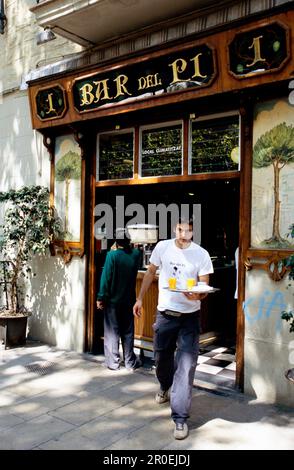 Kellner, der Getränke in der Bar del Pi, Placa del Pi in der Gotischen Altstadt von Barri, Barcelona, Katalonien, Spanien, mit sich führt Stockfoto