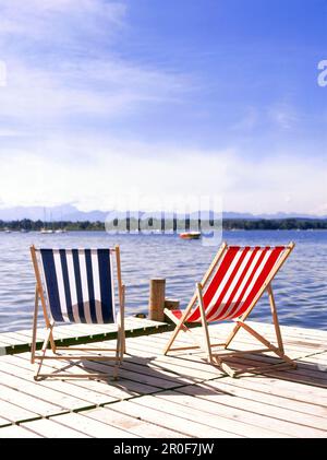 Gestreifte Liegestühle auf dem Steg, Starnberger See, Oberbayern, Deutschland Stockfoto