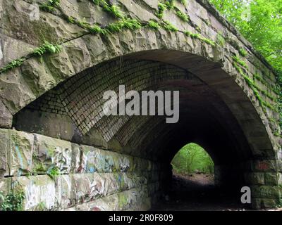 Die Stone Arch Bridge im Fairmount Park von Philadelphia stammt aus dem späten 1800er. Jahrhundert und ist Teil der stillgelegten Straßenbahnlinie der Fairmount Park Transit Company. Stockfoto