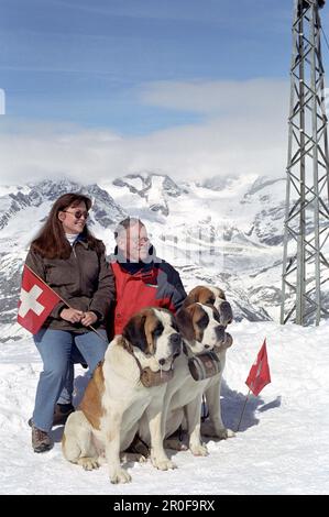 Touristenpaar mit Bernhardiner-Hunden, Zermatt, Schweiz Stockfoto