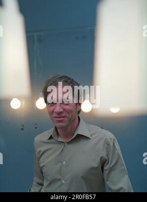 Ein Mann, der in der Küche steht, mit Lichtern um den Kopf Stockfoto