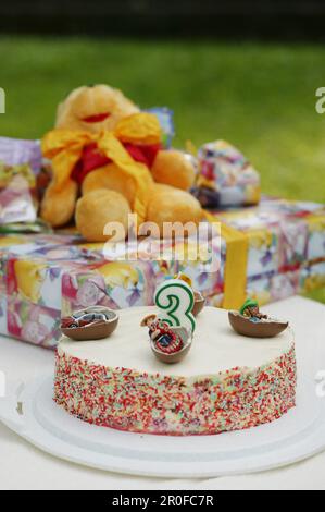 Geburtstagskuchen und Geschenke auf dem Tisch Stockfoto